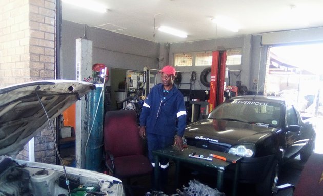 Photo of happy auto electrician and diagnosis