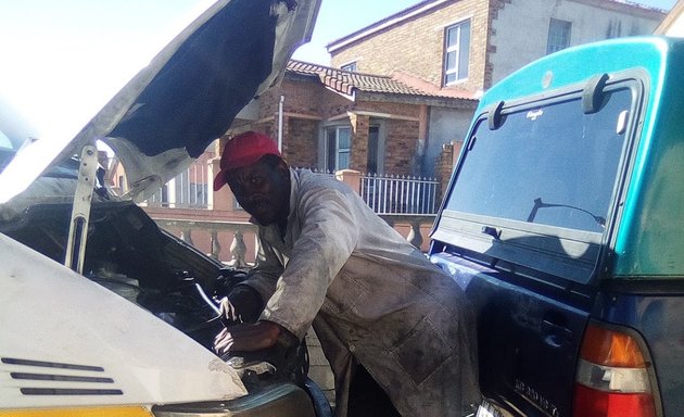 Photo of happy auto electrician and diagnosis