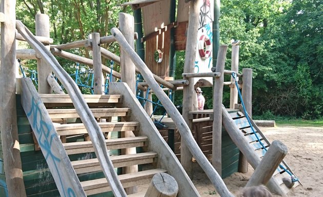 Foto von Spielplatz mit Holzboot und Rutschenturm